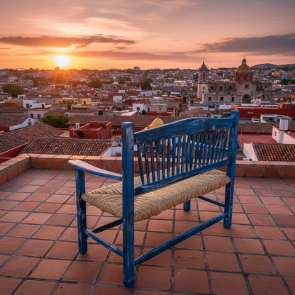 Banca azul vintage en terraza con vista a pueblo colonial al atardecer