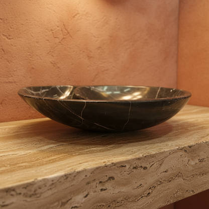 Lavabo de mármol negro nautilus en encimera de travertino baño colonial