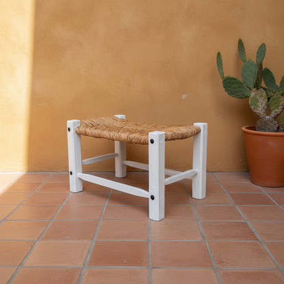 Banca artesanal blanca con tule en patio de hacienda mexicana