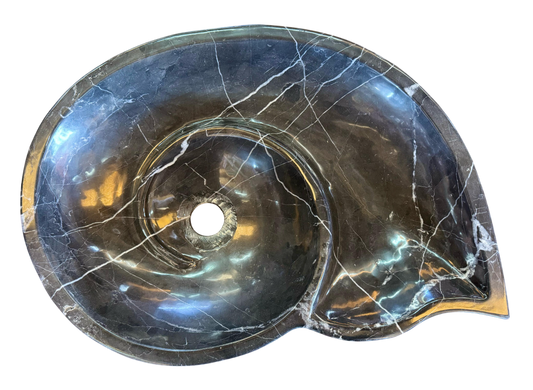 Black marble sink in the shape of a snail fossil
